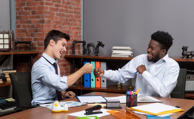 front-view-two-businessmen-fist-bump-together