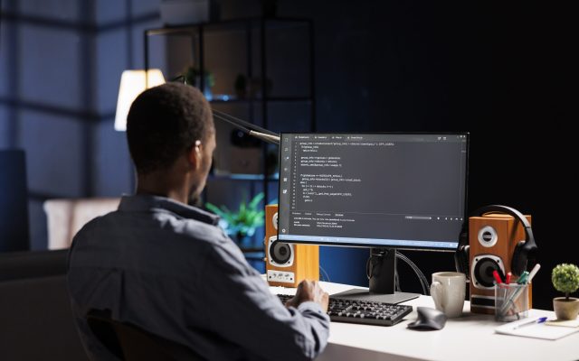 Male developer entering binary data on terminal panel while establishing html code. Software engineer works on troubleshooting with programming language, for protection of databases.